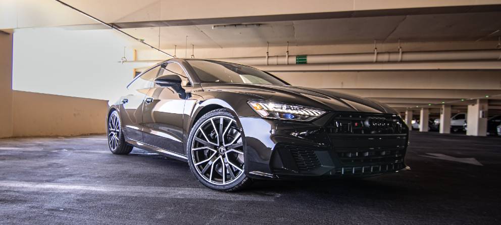 Audi A5 de segunda mano y ocasión negro mal aparcado en una plaza de garaje. Eligetucoche.es