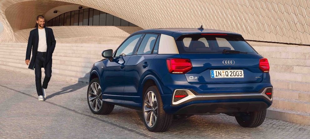 Audi Q2 de segunda mano azul con un hombre de mediana edad dirigiéndose hacia él. | eligetucoche.es