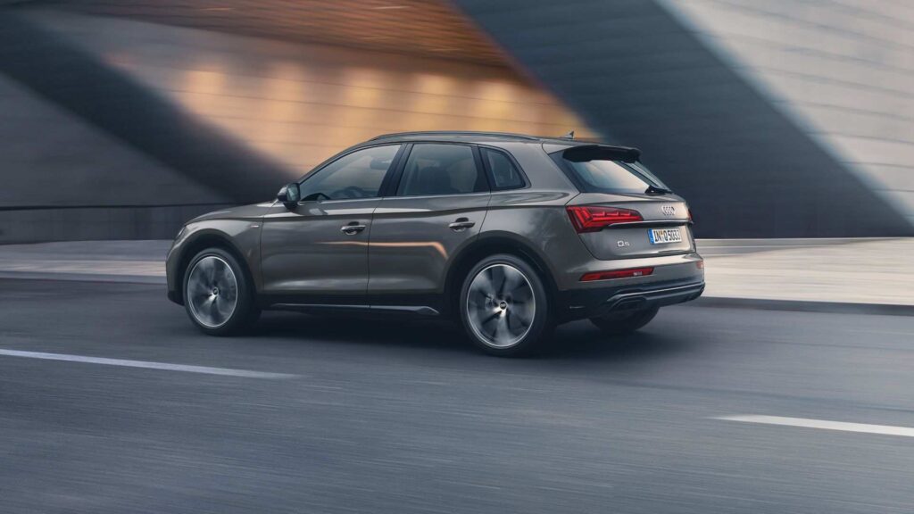 Audi Q5 gris circulando por una carretera con el fondo difuminado. | eligetucoche.es