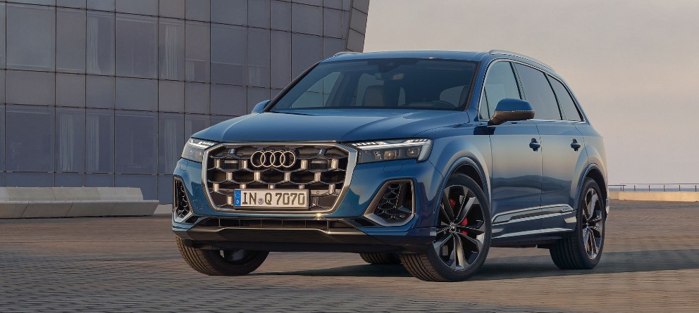 Audi Q7 azul aparcado con un edificio acristalado de fondo. | eligetucoche.es